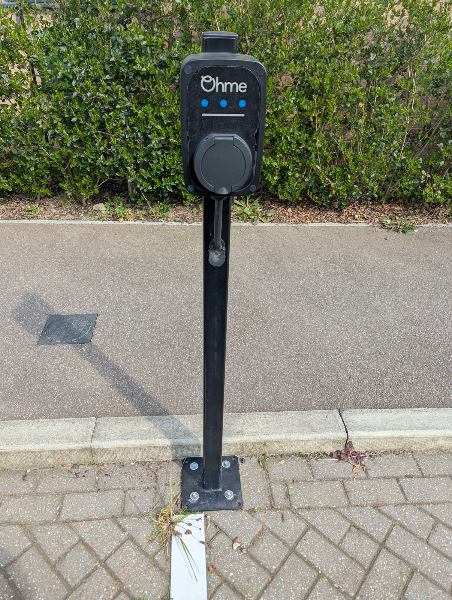 Ohme EV charge point installed on a post-mounted bollard on a block-paved driveway